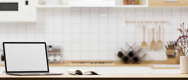 Een draagbare laptop computer wit scherm mockup en kopieer ruimte op moderne houten keuken aanrecht over wazig keuken kamer op de achtergrond. 3d weergave, 3d illustratie - Foto, afbeelding