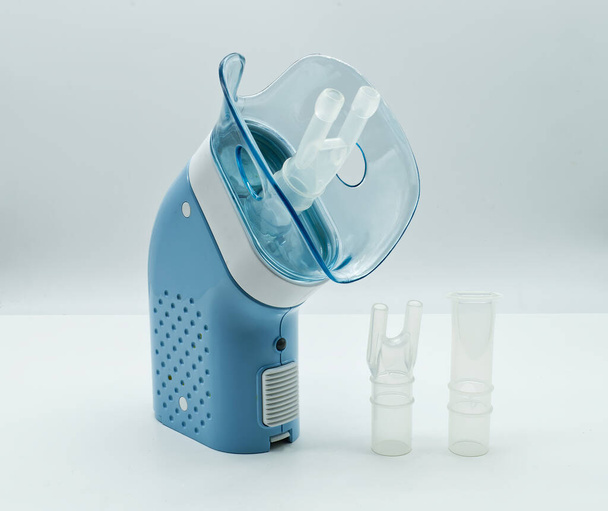 Nebulizador de compresor portátil sobre mesa blanca. Equipos médicos para terapia por inhalación, asma, bronquitis. - Foto, Imagen