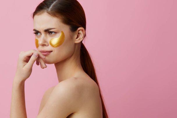 mladá žena zlaté skvrny na tváři izolované pozadí. Kvalitní fotografie - Fotografie, Obrázek