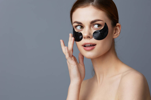 portrait woman eye patches on face bare shoulders skin care close-up Lifestyle. High quality photo - Photo, Image