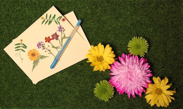 Квіти на траві з чистою вітальною карткою, прикрашеною сушеними квітами - Фото, зображення