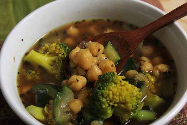 Detailní záběr na mísu polévky s fazolemi Garbanzo, brokolicí a zelenou cuketou - Fotografie, Obrázek