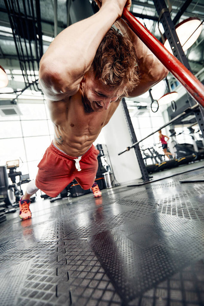 Man fitness training met grote en zware band hits Hammer. Concept workout, Kruis kracht. - Foto, afbeelding