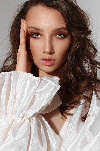Stunning model girl with trendy makeup wearing modish white dress at the studio background. - Φωτογραφία, εικόνα