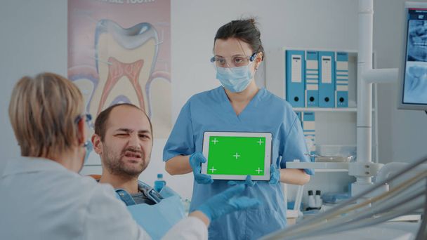 Infirmière et patiente analysant l'écran vert sur tablette numérique - Photo, image