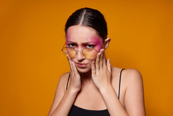 módní žena módní brýle růžová tvář make-up představovat atraktivní vzhled žluté pozadí beze změny - Fotografie, Obrázek