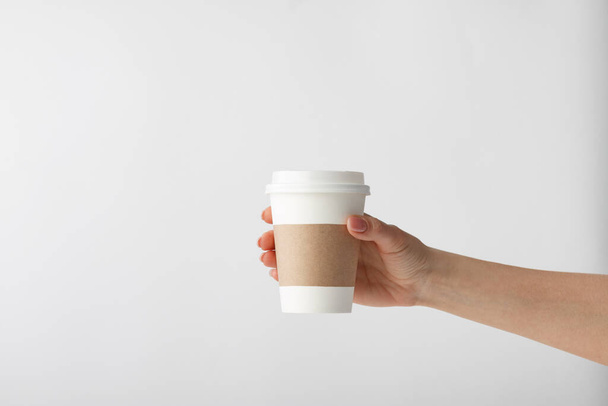 Mano humana sosteniendo una taza de café sobre un fondo blanco - Foto, Imagen