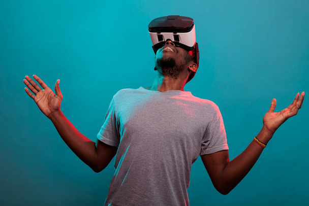 Férfi játékos néz fel, miközben használja a virtuális valóság headset - Fotó, kép