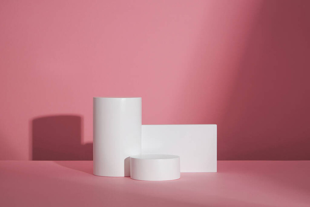 Círculo, podio blanco cuadrado, en fondo rosa y espacio en blanco para publicidad, contenido abstracto, vista frontal - Foto, imagen
