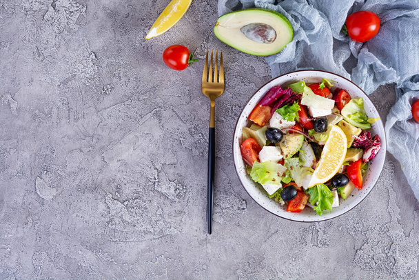 Čerstvý salát s rajčaty, salátem, avokádem, olivami, fetou a pepřem. Dietní stravování - Fotografie, Obrázek