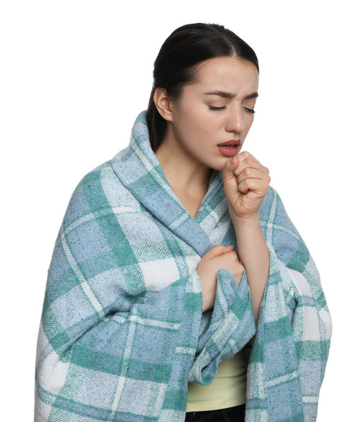 Young woman wrapped in blanket coughing on white background. Cold symptoms - Fotografie, Obrázek