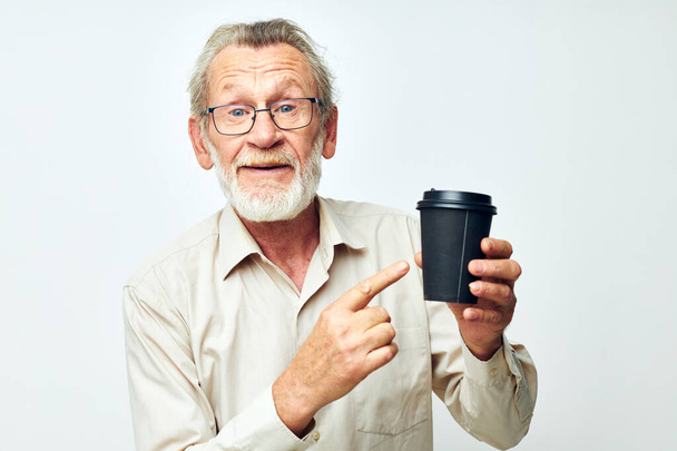 Photo of retired old man in a shirt and glasses a black glass isolated background - Fotó, kép