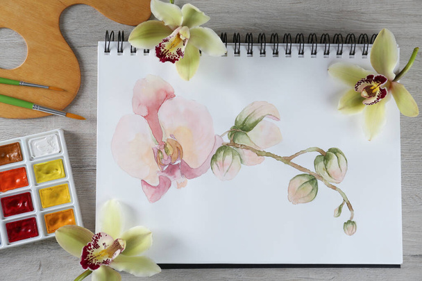 Flat lay composition with beautiful drawing of orchid - Photo, image