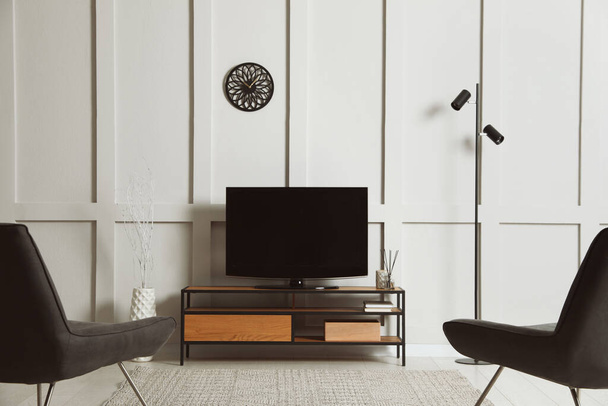 Elegante interior de quarto com TV moderna em stand e poltronas - Foto, Imagem
