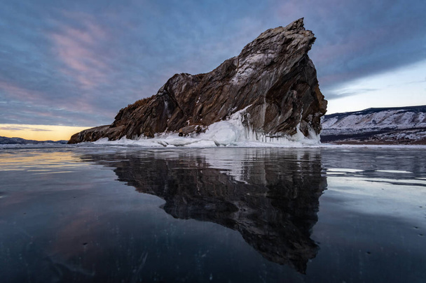 Reflection of a rocky island in the surface of the Baikal ice - 写真・画像