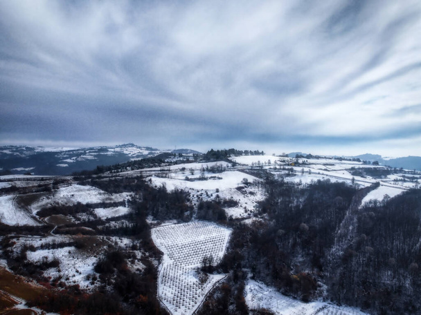 Wieś Murazzano z wieżą i wioską w Piemontese Langhe w prowincji Cuneo, w pokryty śniegiem zimowy dzień - Zdjęcie, obraz