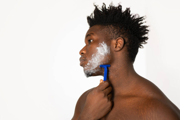 portrait of an african male with a razor on a white background - Foto, Imagem