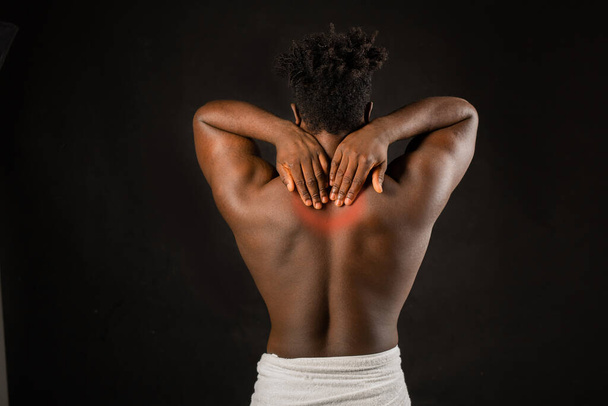 Back pain in the neck of an African male neck - 写真・画像