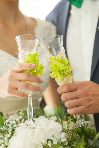 Ruce nevěsty a ženicha se svatebními brýlemi. Koncept slavnostních nápojů a jídel. - Fotografie, Obrázek