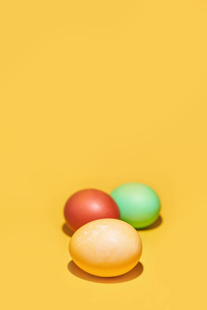 Huevos de Pascua pintados sobre un fondo amarillo. Con espacio para copiar - Foto, imagen