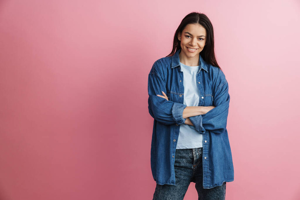 Young hispanic smiling woman posing with arms crossed isolated over pink wall - Foto, Imagem