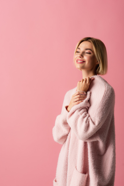 happy young woman in soft cardigan isolated on pink  - Foto, afbeelding