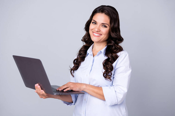 Photo of positive freelance programmer lady hold netbook typing wear blue shirt isolated grey color background - Fotografie, Obrázek