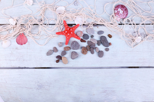 Decor of seashells and seastar close-up on blue wooden table - Photo, image