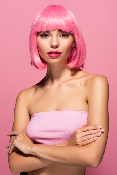 young woman with colored hair and bangs standing with crossed arms isolated on pink  - Фото, зображення
