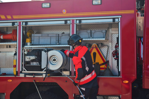 Strażak wychodzi z wozu strażackiego przed ugaszeniem pożaru - Zdjęcie, obraz