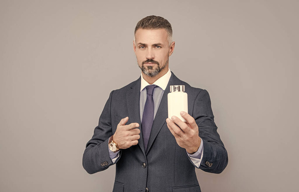 уверенный в себе бизнесмен в деловом костюме, представляющий медицинский продукт банка с таблетками, медицинский бизнес - Фото, изображение