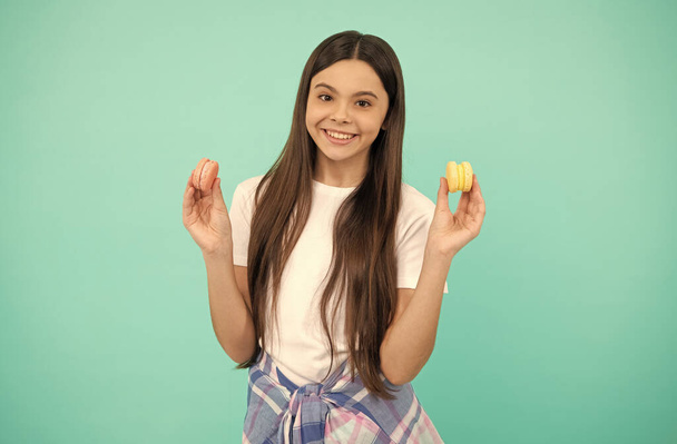 šťastný dospívající dívka držet francouzsky macaron nebo makarón cookies, cukrovinky - Fotografie, Obrázek