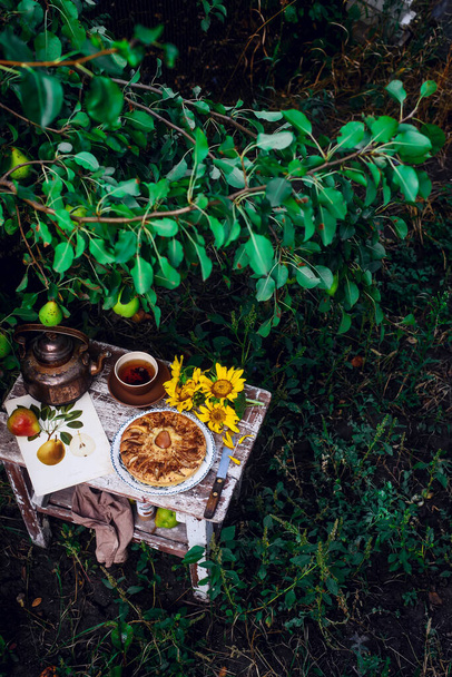 Pastel de pera en una mesa de madera en el jardín .enfoque selectivo. estilo rústico - Foto, imagen