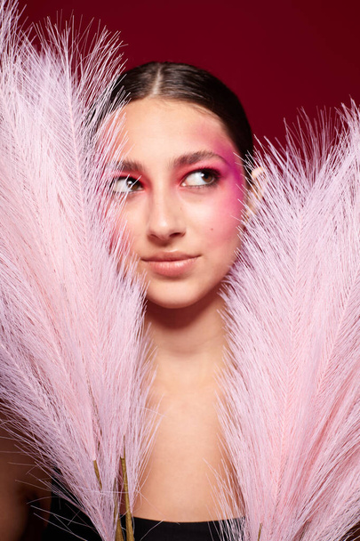 pretty woman bright makeup posing fashion emotions feather decoration studio model - Foto, afbeelding