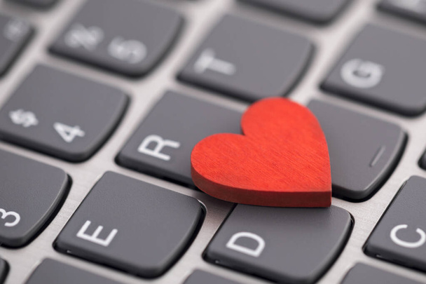 Small red heart on computer keyboard. Internet dating concept. - Foto, imagen
