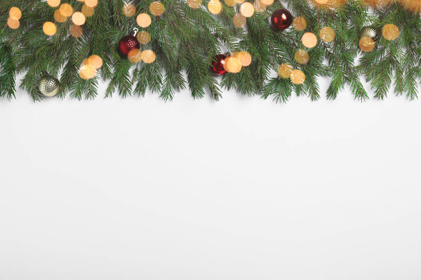 Плоская композиция с елочными ветвями и рождественским декором на белом фоне, пространство для текста. Эффект Боке - Фото, изображение