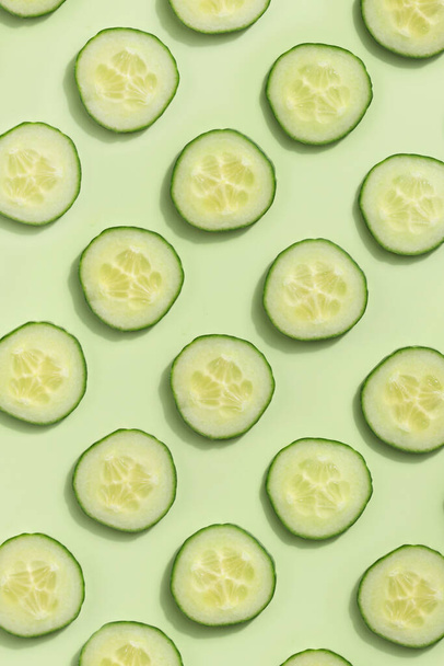 Cucumber slices on a green background - Photo, Image