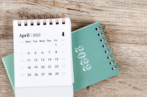 The April 2022 desk calendar on wooden background. - Foto, afbeelding