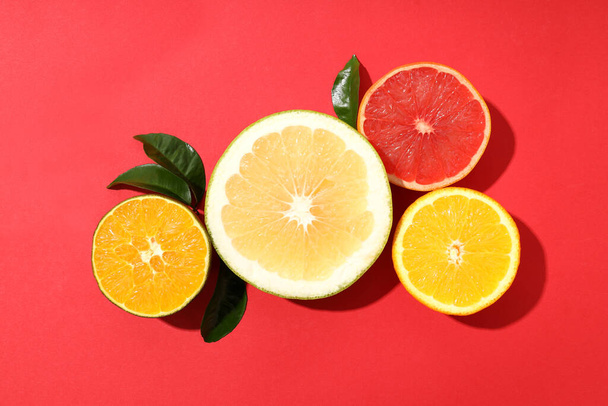 Citrus fruits with leaves on red background - Photo, Image