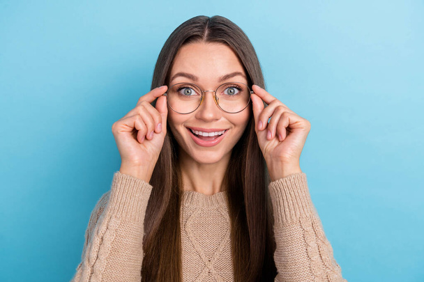 Photo of cheerful excited surprised lady look camera wear eyewear beige sweater isolated blue color background - Foto, Imagen