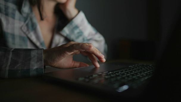 Woman browsing internet in front of laptop screen at night - Valokuva, kuva