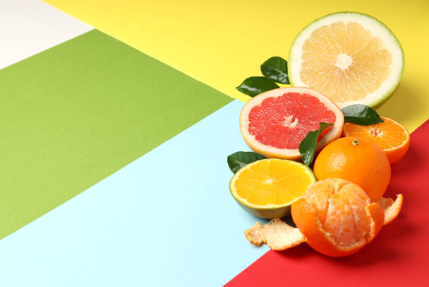 Citrus fruits with leaves on multicolored background - Foto, imagen
