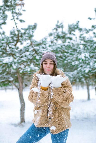 Young cute girl has fun in snowy weather in winter in the park. Life style  - Fotoğraf, Görsel