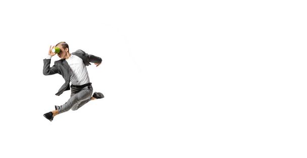 Flyer with young man in gray business suit dancing, jumping isolated on white background. Business, art, motion, action, creativity, inspiration concept. - 写真・画像