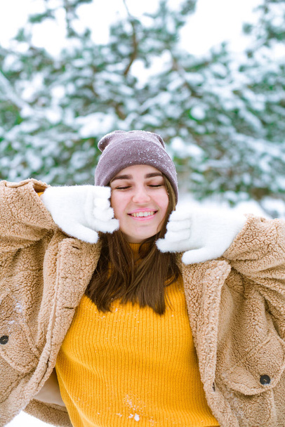 Young cute girl has fun in snowy weather in winter in the park. Life style  - Foto, Imagem
