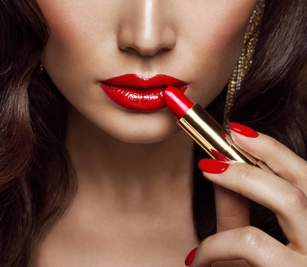 Beauty Model applying Red Lipstick. Woman Gloss Lips Make up and Nail Polish Close up. Glamour Face Makeup Cosmetics - Foto, Imagen