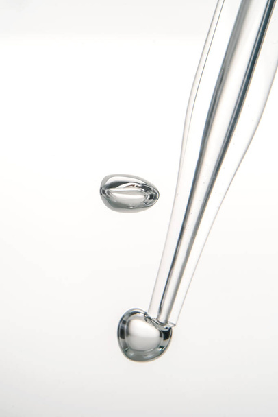 Pipette with cosmetic product in water with bubbles. - Valokuva, kuva