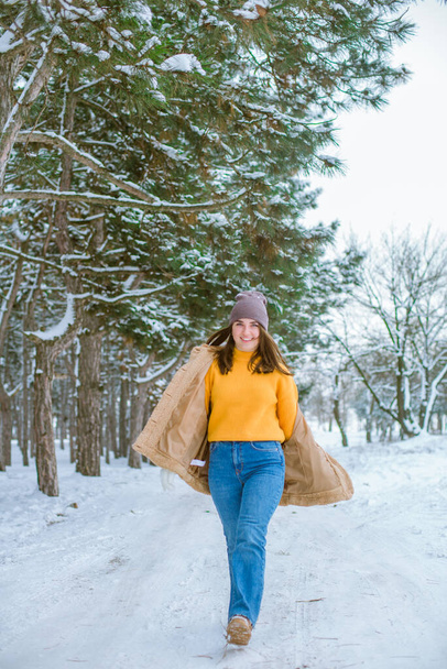 Young cute girl has fun in snowy weather in winter in the park. Life style  - 写真・画像