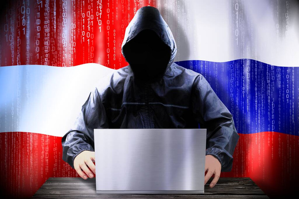 Anonymous hacker working on a laptop, flags of Austria and Russia - Photo, Image
