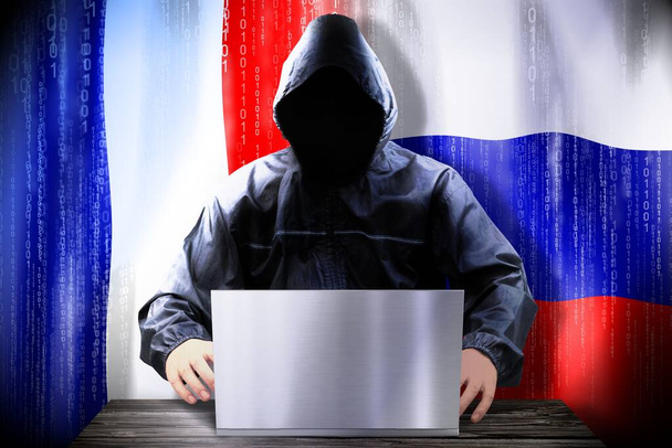 hacker anónimo trabajando en una computadora portátil, banderas de Francia y Rusia - Foto, Imagen